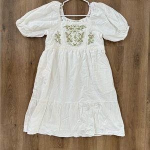White dress with green embroidery.